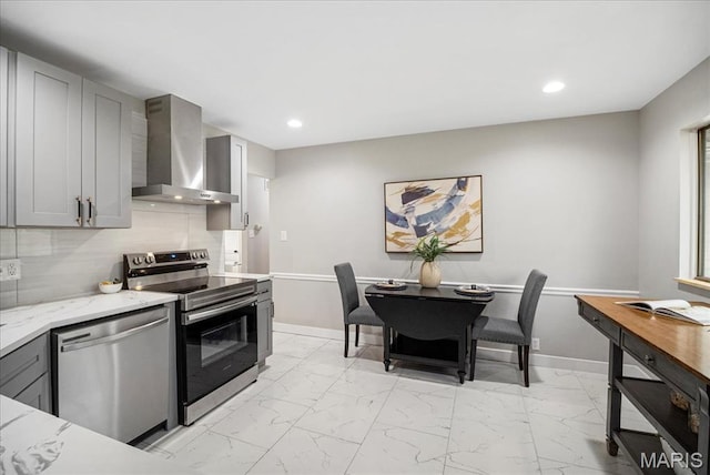 4501 Conleth Dr, Saint Louis, MO 63129 - kitchen featuring appliances with stainless steel finishes, wall chimney exhaust hood, light marble finish flooring, gray cabinets, and baseboards
