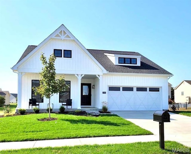 modern inspired farmhouse with covered porch, a front yard, driveway, a garage, and board and batten siding