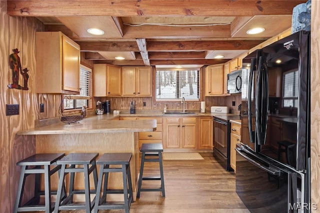 353 Seebrook Lake Dr, Wright City, MO 63390 - kitchen featuring black appliances, light countertops, light wood-style flooring, light brown cabinets, and a breakfast bar area