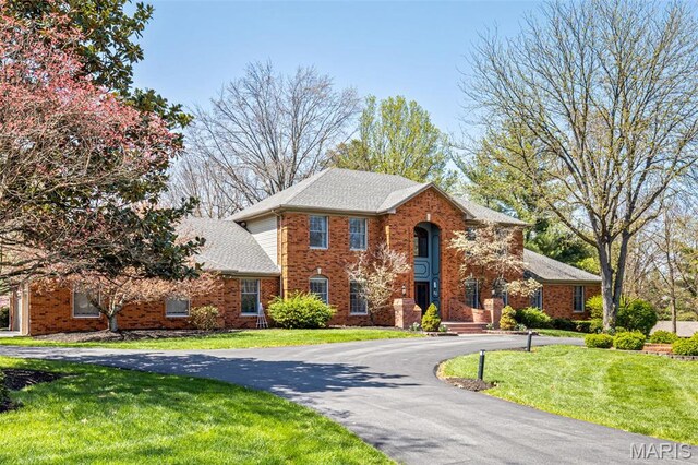 113 Ladue Aire Dr, Creve Coeur, MO 63141 - colonial house with curved driveway, a front yard, brick siding, and a shingled roof