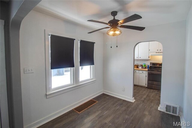 330 Grant St, Bethalto, IL 62010 - empty room with dark wood-type flooring, ceiling fan, arched walkways, and baseboards