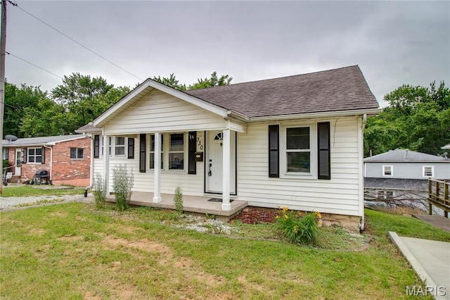 330 Grant St, Bethalto, IL 62010 - view of front facade with a porch, roof with shingles, and a front lawn