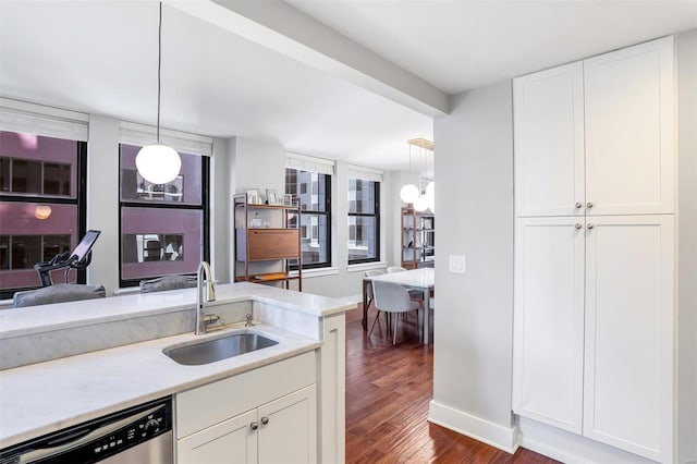 kitchen featuring stainless steel dishwasher, a sink, dark wood finished floors, and white cabinets