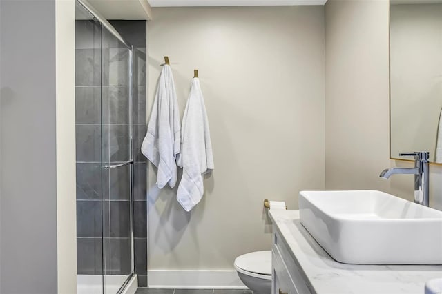 bathroom with a shower stall, baseboards, toilet, and vanity
