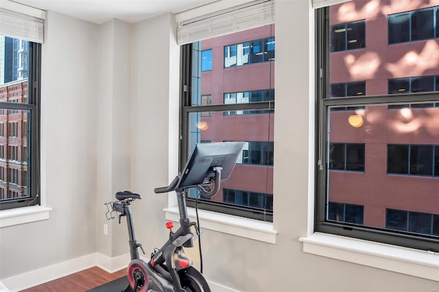 exercise area featuring baseboards and wood finished floors