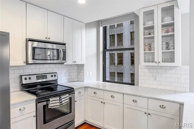 314 N Broadway Unit 903, Saint Louis, MO 63102 - kitchen with stainless steel appliances, white cabinets, glass insert cabinets, and decorative backsplash