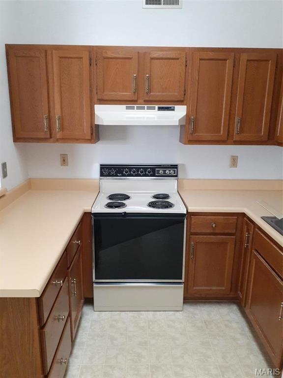 161 Eagle Rdg Unit 163-306, Ofallon, IL 62269 - kitchen featuring under cabinet range hood, electric range oven, brown cabinetry, and light countertops