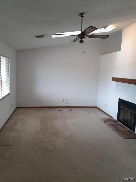 161 Eagle Rdg Unit 163-306, Ofallon, IL 62269 - unfurnished living room with a ceiling fan, light colored carpet, a glass covered fireplace, and baseboards