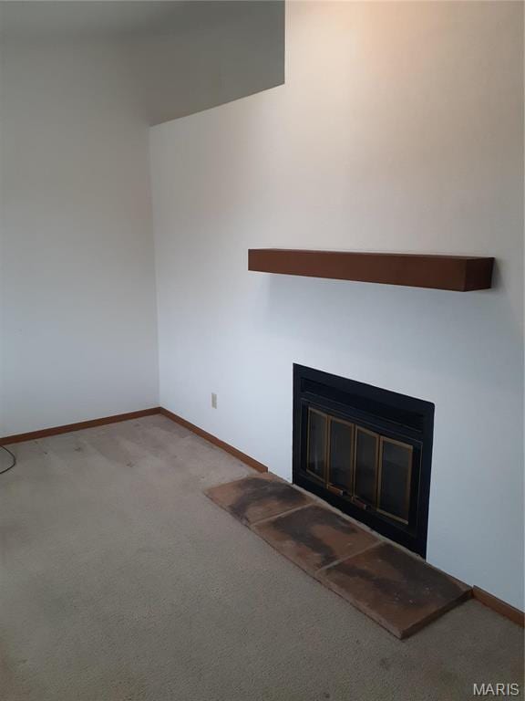 161 Eagle Rdg Unit 163-306, Ofallon, IL 62269 - unfurnished living room featuring a glass covered fireplace, carpet floors, and baseboards