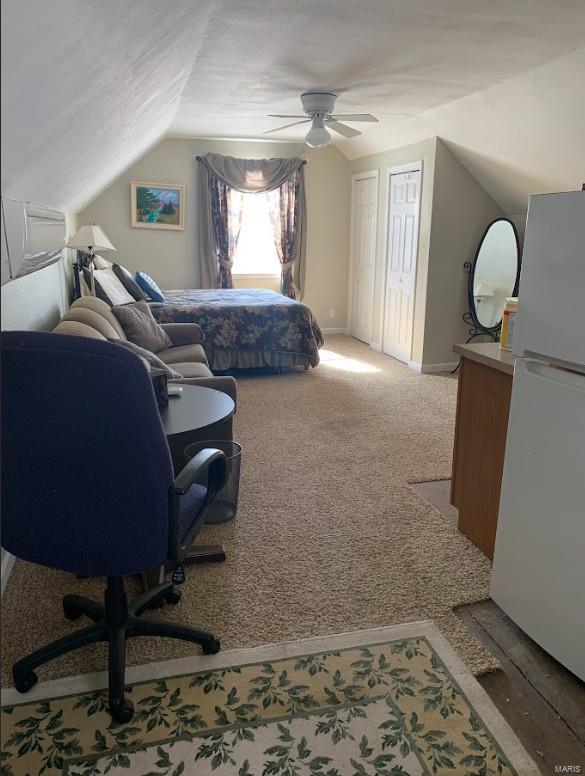 902 S Sutton Pl, Kennett, MO 63857 - bedroom with freestanding refrigerator, lofted ceiling, a desk, ceiling fan, and baseboards