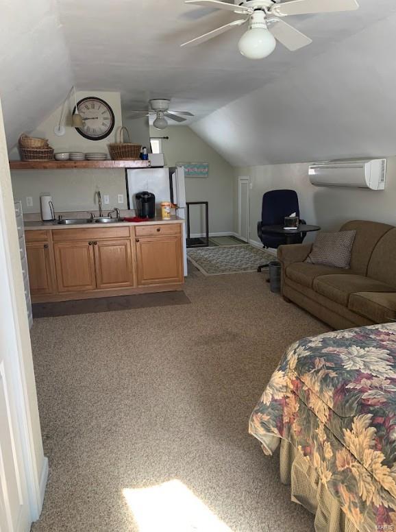 902 S Sutton Pl, Kennett, MO 63857 - bedroom with a sink, a wall mounted air conditioner, vaulted ceiling, baseboards, and light colored carpet