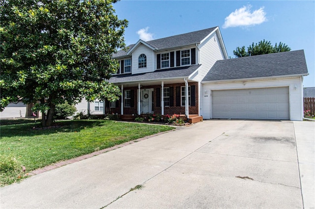 colonial home with a garage, driveway, a front lawn, a porch, and brick siding