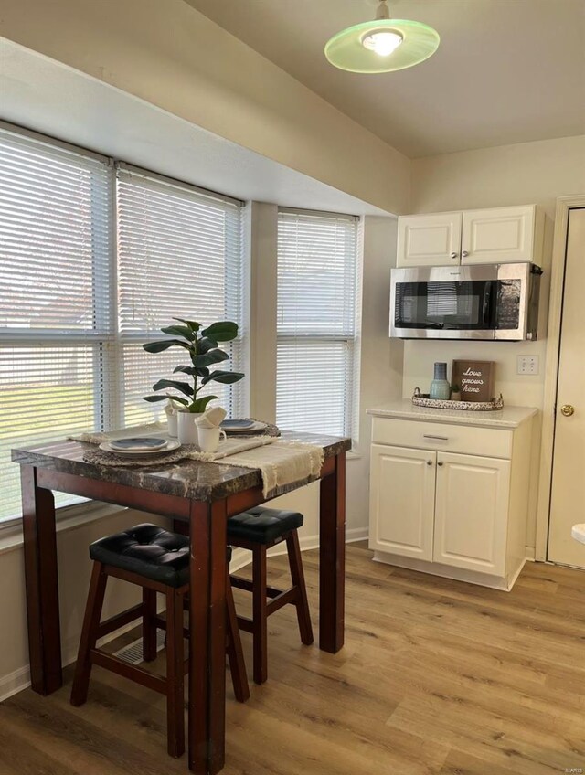 dining area featuring light wood-style floors and baseboards