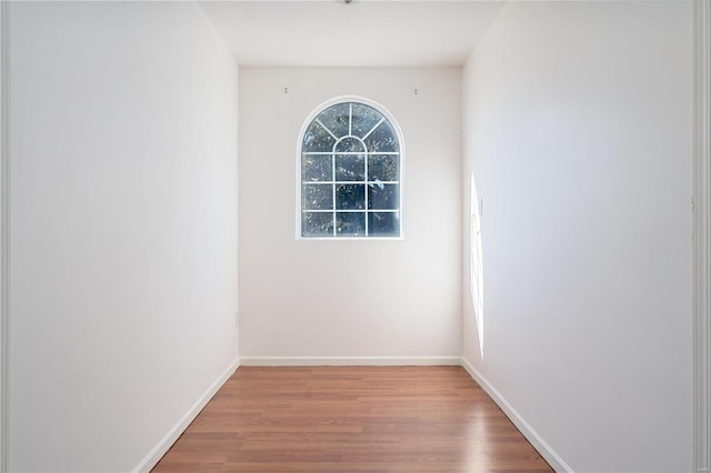 empty room featuring wood finished floors and baseboards