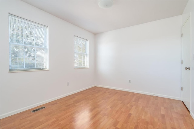 unfurnished room with light wood-type flooring and baseboards