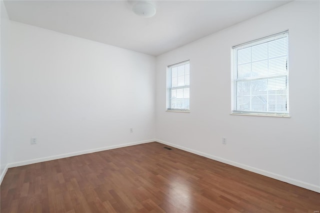 unfurnished room with dark wood-style floors and baseboards