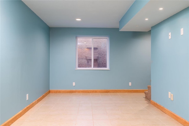 spare room with recessed lighting and baseboards