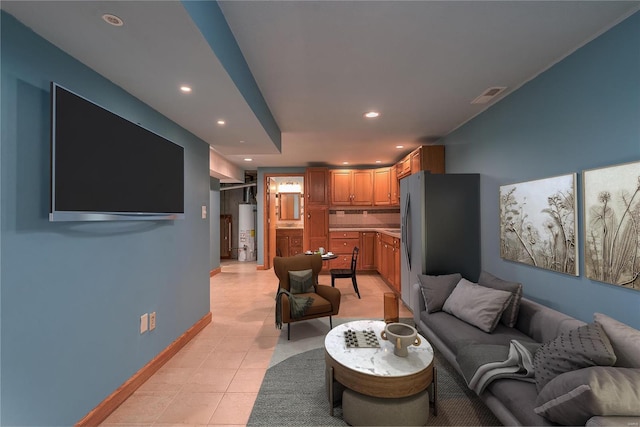 living room with water heater, recessed lighting, light tile patterned floors, and baseboards
