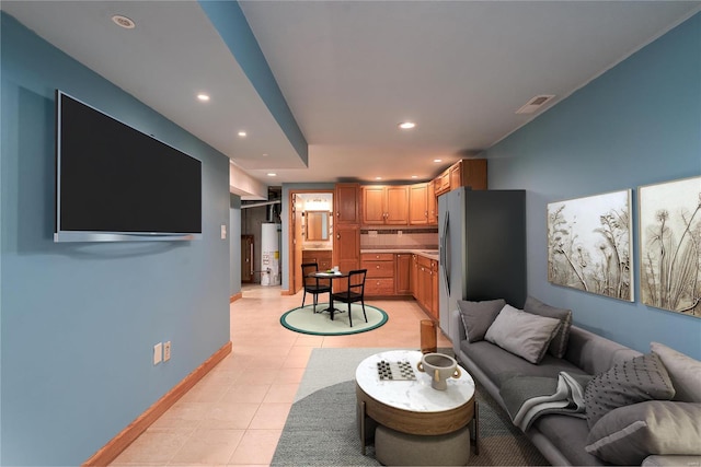 living room featuring water heater, recessed lighting, light tile patterned floors, and baseboards