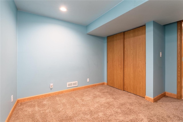 unfurnished bedroom with light colored carpet, baseboards, recessed lighting, and a closet