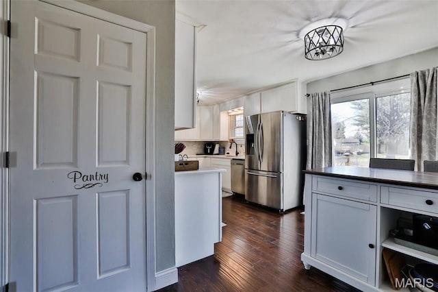 kitchen featuring appliances with stainless steel finishes, dark wood-style flooring, and white cabinets