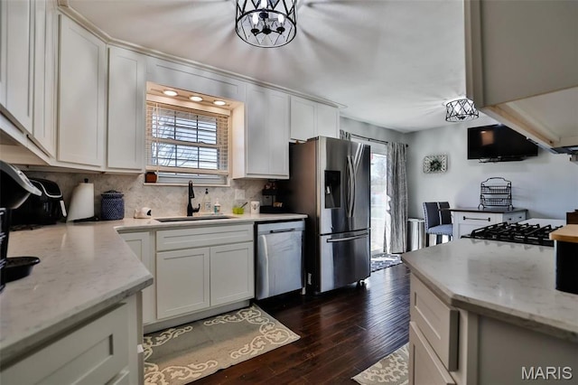 kitchen with appliances with stainless steel finishes, a sink, and white cabinets