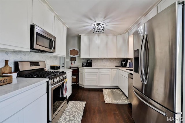 kitchen featuring appliances with stainless steel finishes, tasteful backsplash, white cabinets, and dark wood-style floors