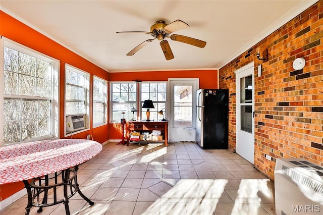 sunroom / solarium featuring brick wall, a ceiling fan, tile patterned flooring, ornamental molding, and cooling unit