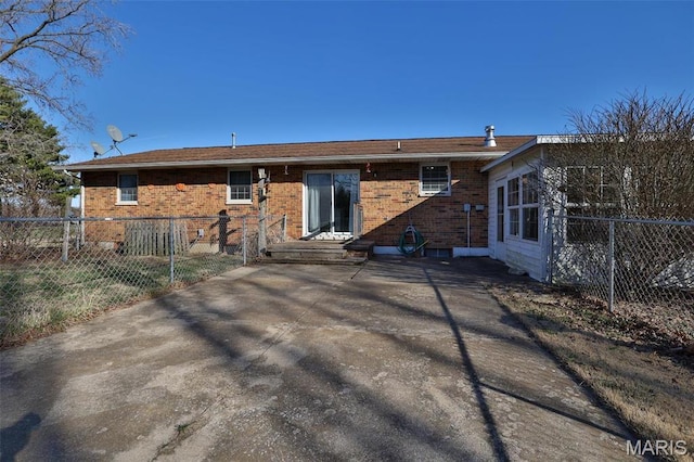 rear view of house featuring fence, brick siding, and a patio