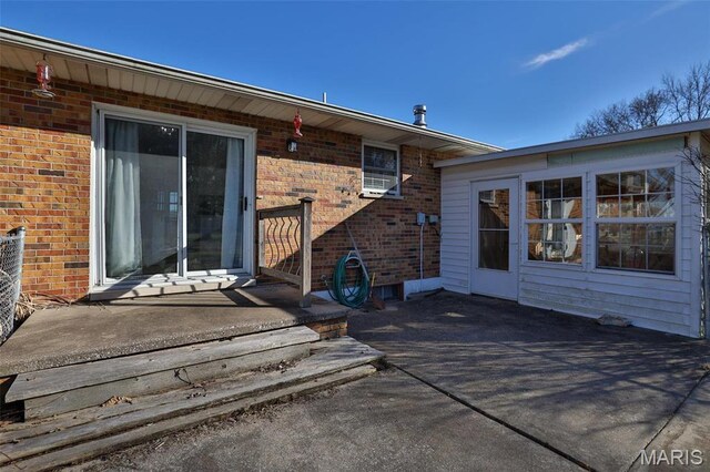 rear view of property featuring brick siding and a patio