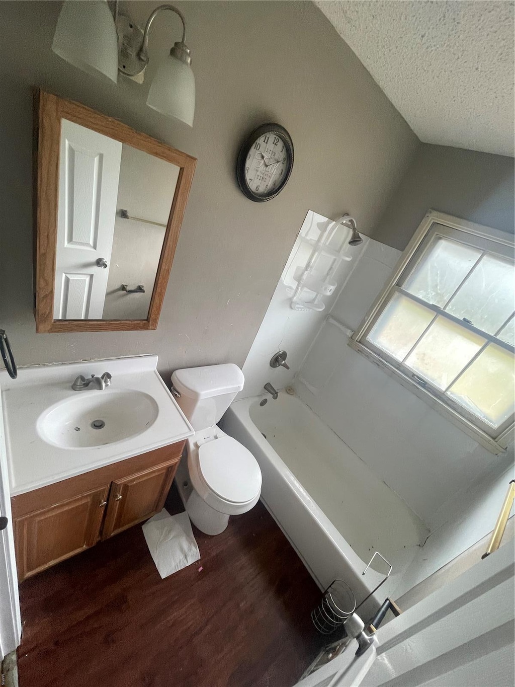 10331 Renfrew Dr, Saint Louis, MO 63137 - full bath featuring wood finished floors, toilet, a tub to relax in, vanity, and a textured ceiling