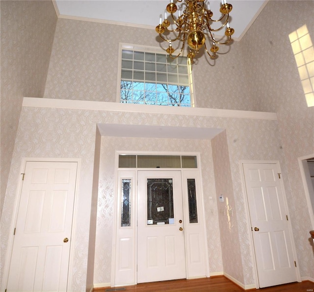 821 Oak Knoll Rd, Rolla, MO 65401 - entrance foyer featuring a chandelier, ornamental molding, wallpapered walls, and wood finished floors