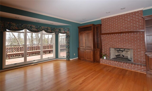 821 Oak Knoll Rd, Rolla, MO 65401 - unfurnished living room featuring light wood-type flooring, a brick fireplace, crown molding, and baseboards