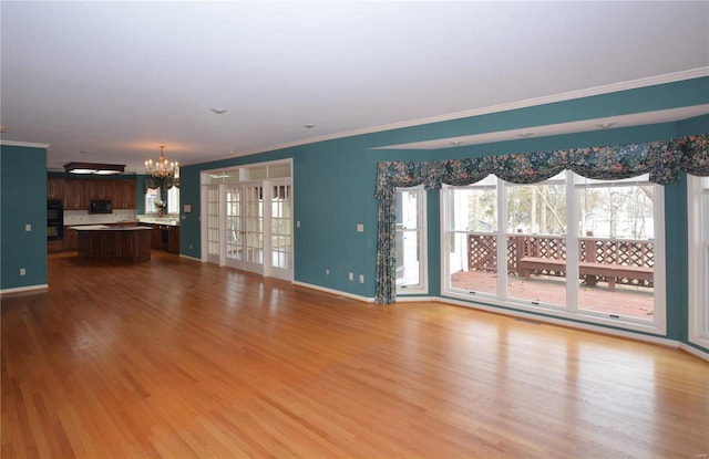 821 Oak Knoll Rd, Rolla, MO 65401 - unfurnished living room featuring a chandelier, wood finished floors, crown molding, and baseboards