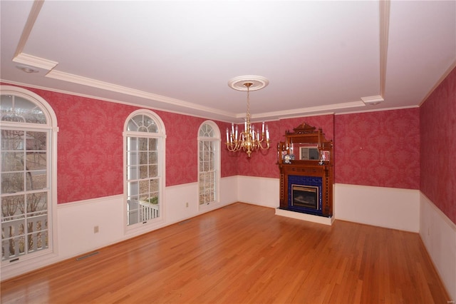 821 Oak Knoll Rd, Rolla, MO 65401 - unfurnished living room featuring a chandelier, wood finished floors, a wainscoted wall, a fireplace, and wallpapered walls