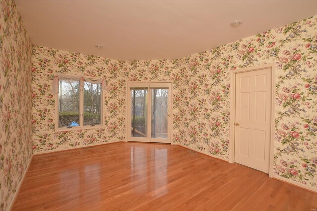 821 Oak Knoll Rd, Rolla, MO 65401 - unfurnished room featuring wood finished floors, wallpapered walls, and baseboards