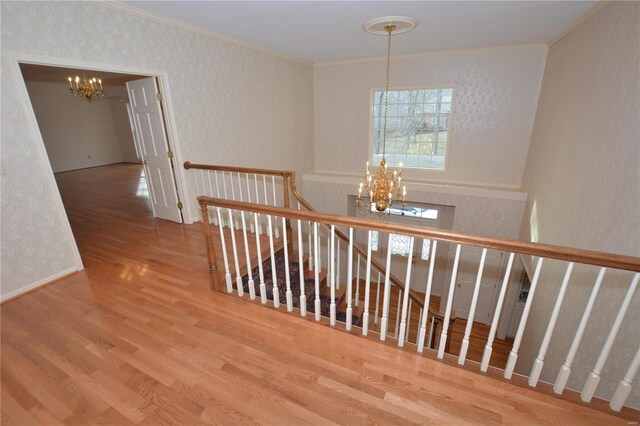 821 Oak Knoll Rd, Rolla, MO 65401 - hall with a chandelier, an upstairs landing, ornamental molding, wood finished floors, and wallpapered walls
