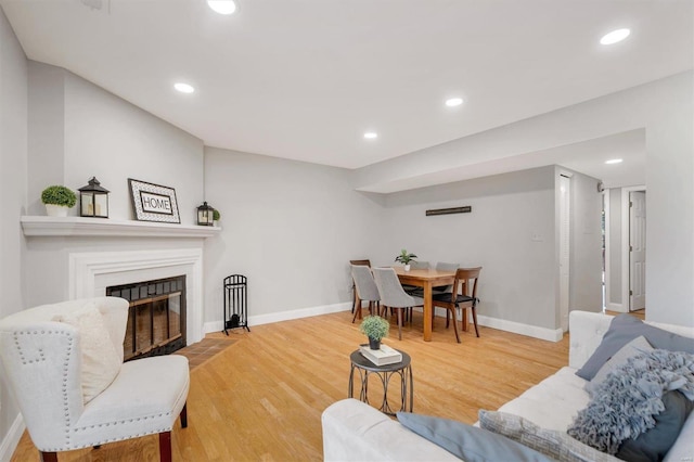 1418 Bluebird Ter, Saint Louis, MO 63144 - living area with a fireplace with flush hearth, wood finished floors, baseboards, and recessed lighting