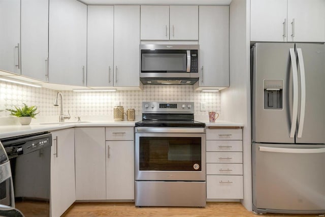 1418 Bluebird Ter, Saint Louis, MO 63144 - kitchen with stainless steel appliances, a sink, light countertops, and decorative backsplash