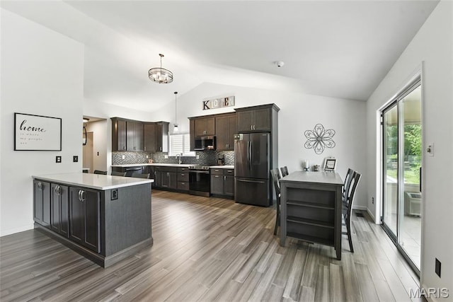 429 Arbor Meadow Ct, Ballwin, MO 63021 - kitchen featuring stainless steel appliances, a peninsula, lofted ceiling, wood finished floors, and tasteful backsplash