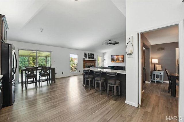 429 Arbor Meadow Ct, Ballwin, MO 63021 - kitchen with freestanding refrigerator, open floor plan, a kitchen bar, a ceiling fan, and dark wood finished floors