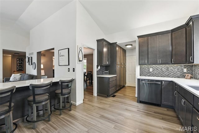 429 Arbor Meadow Ct, Ballwin, MO 63021 - kitchen featuring stainless steel dishwasher, backsplash, light countertops, dark brown cabinets, and light wood finished floors