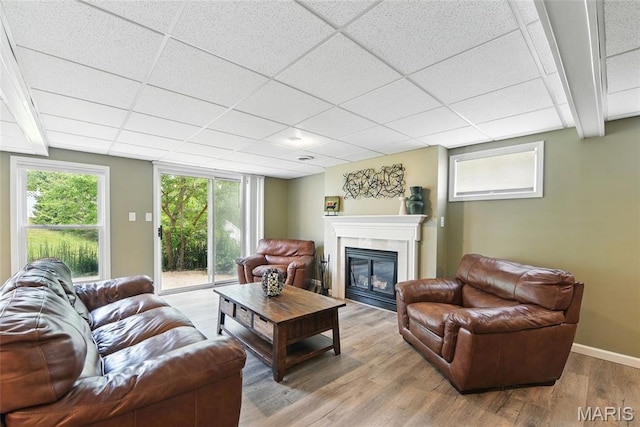 429 Arbor Meadow Ct, Ballwin, MO 63021 - living room featuring wood finished floors, a glass covered fireplace, baseboards, and a drop ceiling