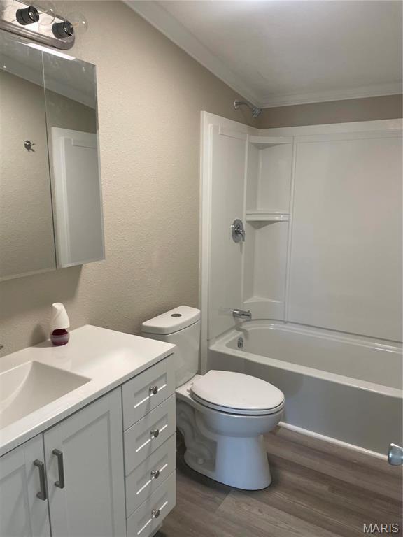 61 Wildwood Ter, Sullivan, MO 63080 - bathroom featuring wood finished floors, vanity, tub / shower combination, toilet, and ornamental molding