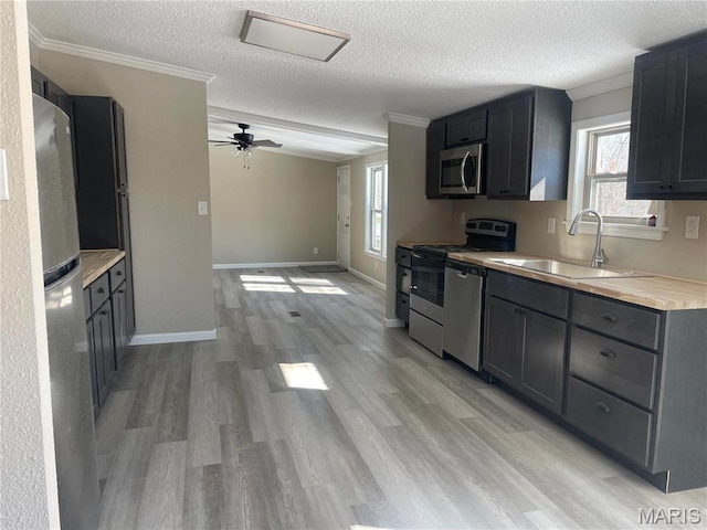 61 Wildwood Ter, Sullivan, MO 63080 - kitchen with a sink, appliances with stainless steel finishes, a textured ceiling, light wood-style flooring, and ceiling fan