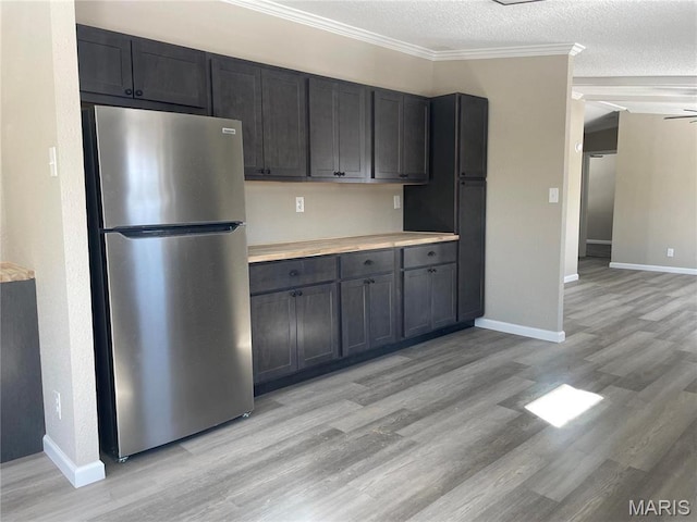 61 Wildwood Ter, Sullivan, MO 63080 - kitchen with freestanding refrigerator, light wood-style flooring, baseboards, a textured ceiling, and ornamental molding