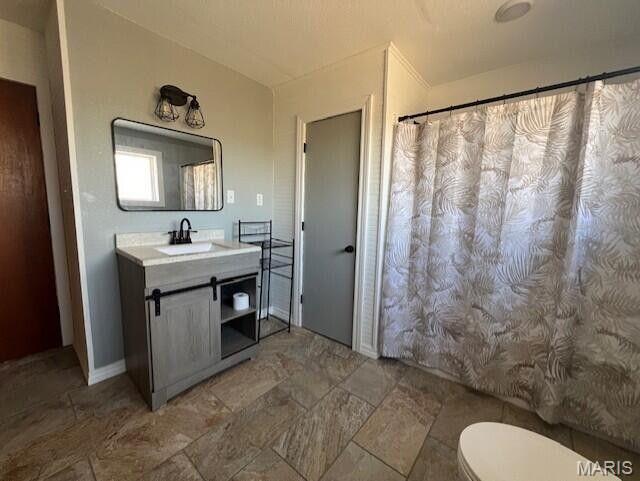 11498 M-Weatherman Dr, Mountain Grove, MO 65711 - full bathroom with toilet, vanity, stone finish flooring, and baseboards