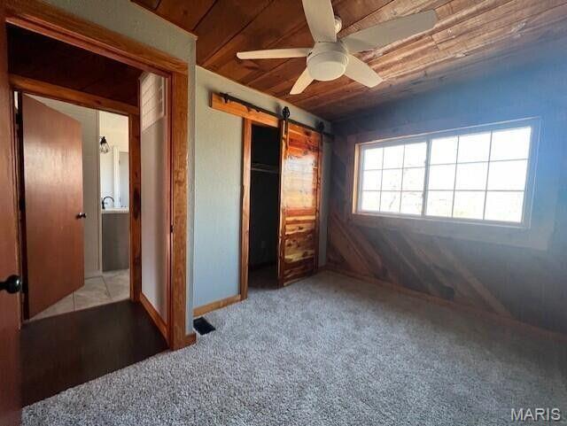 11498 M-Weatherman Dr, Mountain Grove, MO 65711 - unfurnished bedroom featuring a barn door, wooden ceiling, carpet floors, a closet, and ceiling fan