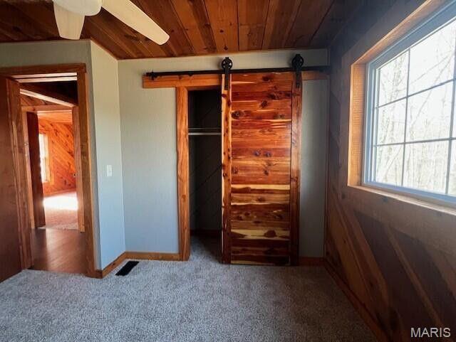 11498 M-Weatherman Dr, Mountain Grove, MO 65711 - unfurnished bedroom with a barn door, carpet flooring, wood ceiling, and baseboards