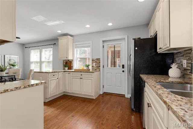 7603 Devonshire Ave, Shrewsbury, MO 63119 - kitchen with recessed lighting, a peninsula, decorative backsplash, wood finished floors, and gas stovetop